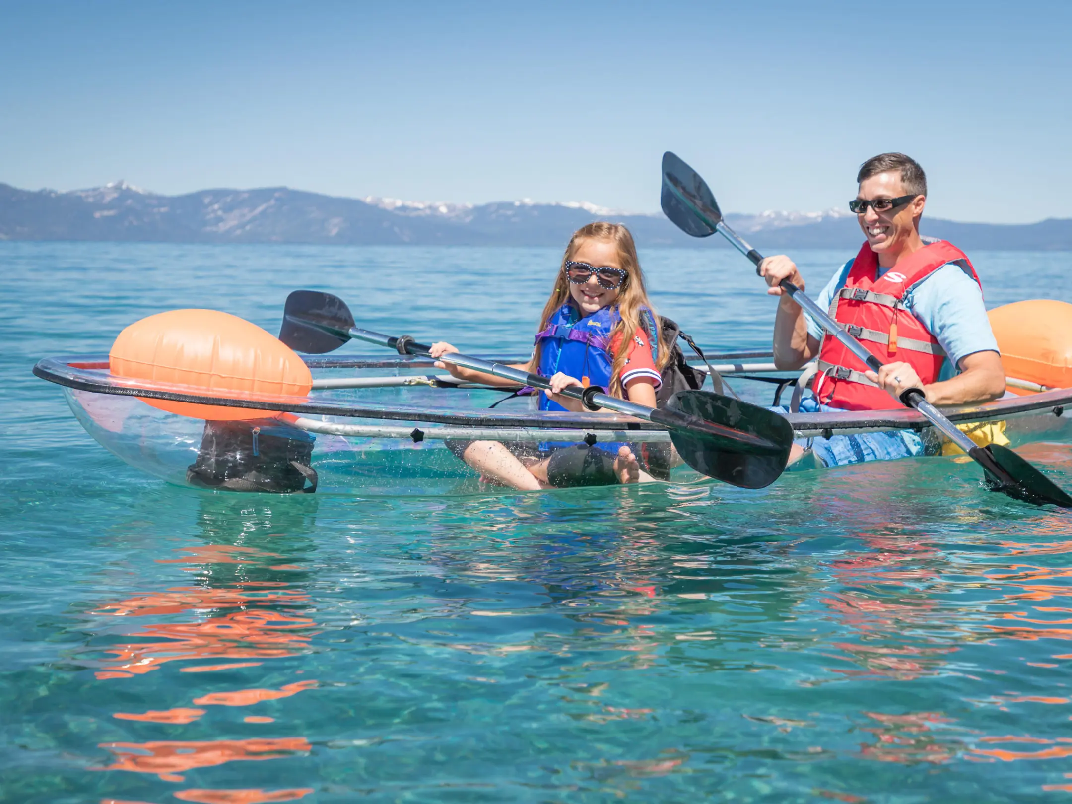 Father and daughter in a clear kayak