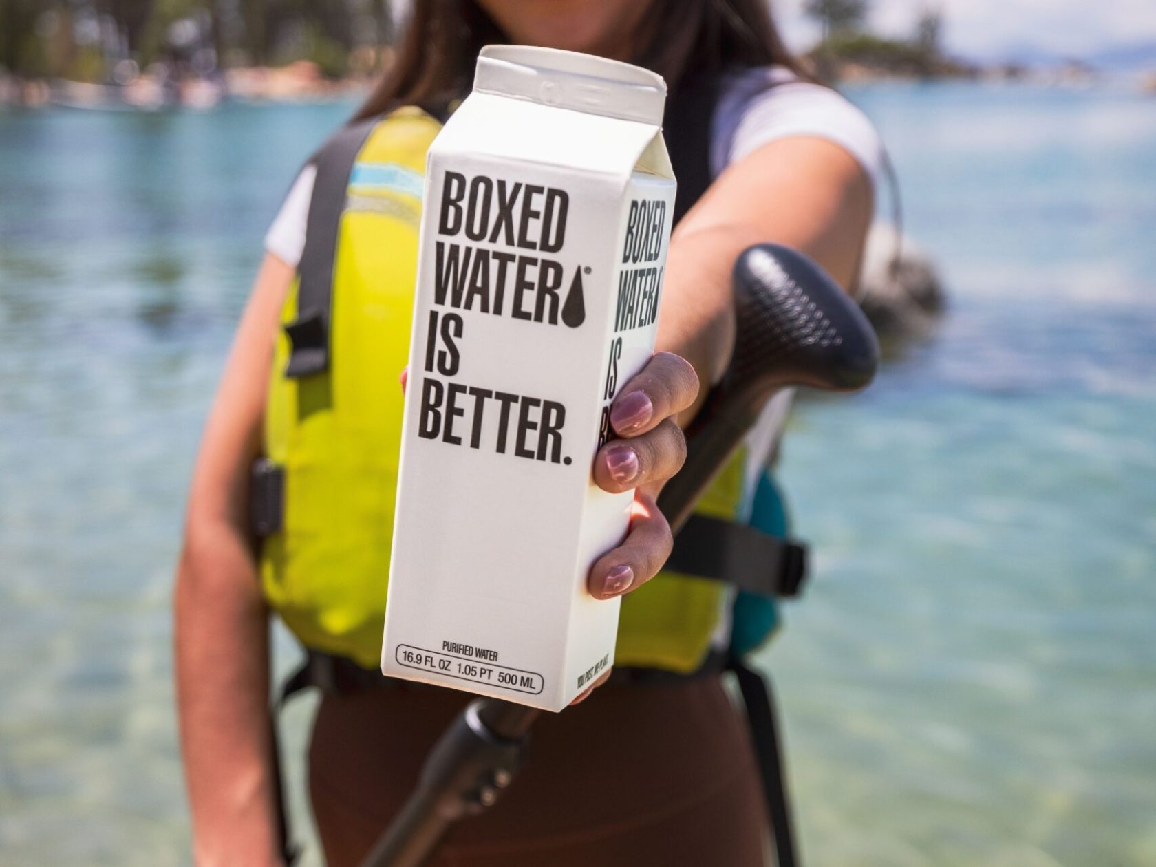 Woman SUP on Lake Tahoe staying hydrated with Boxed Water