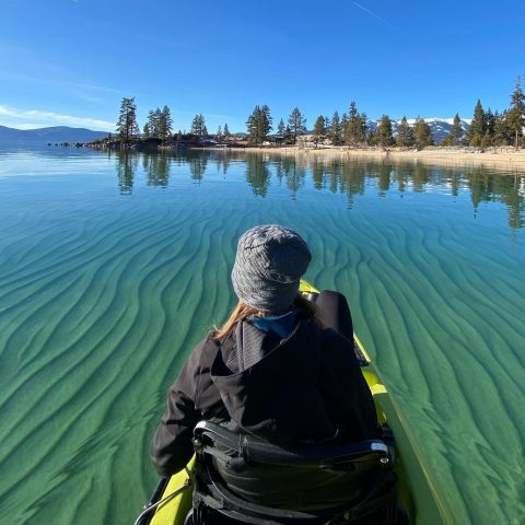 a man standing next to a body of water
