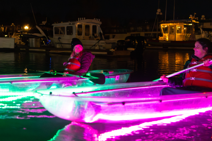 a group of men riding on the back of a boat in the water