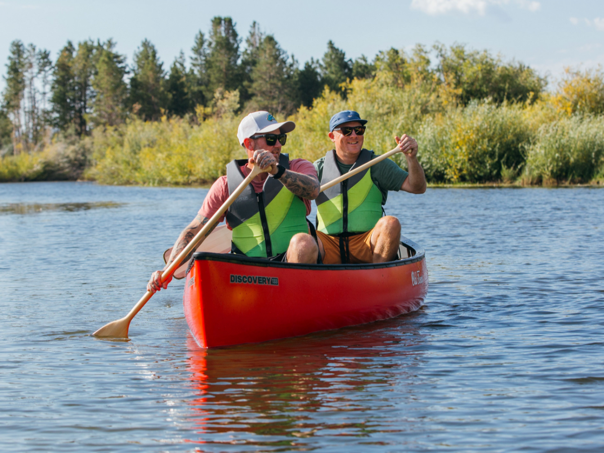 a man riding on the back of a boat in a body of water