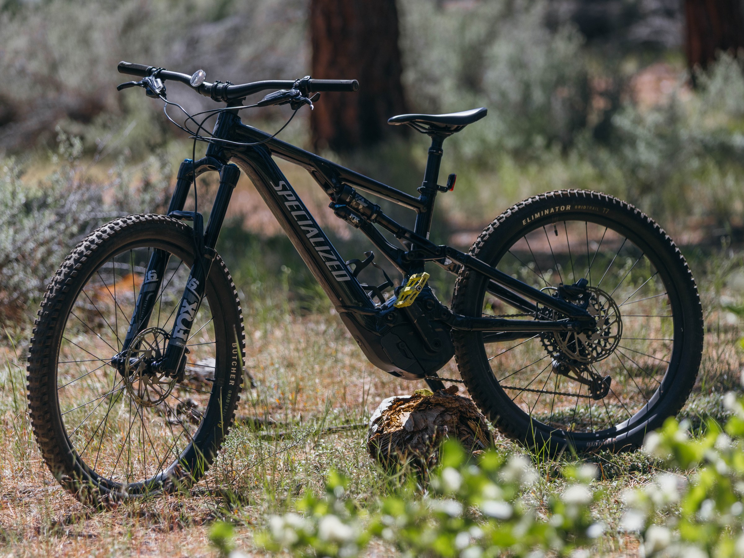 a bicycle parked on the side of a dirt field