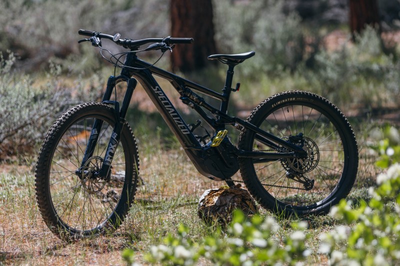a bicycle parked on the side of a dirt field