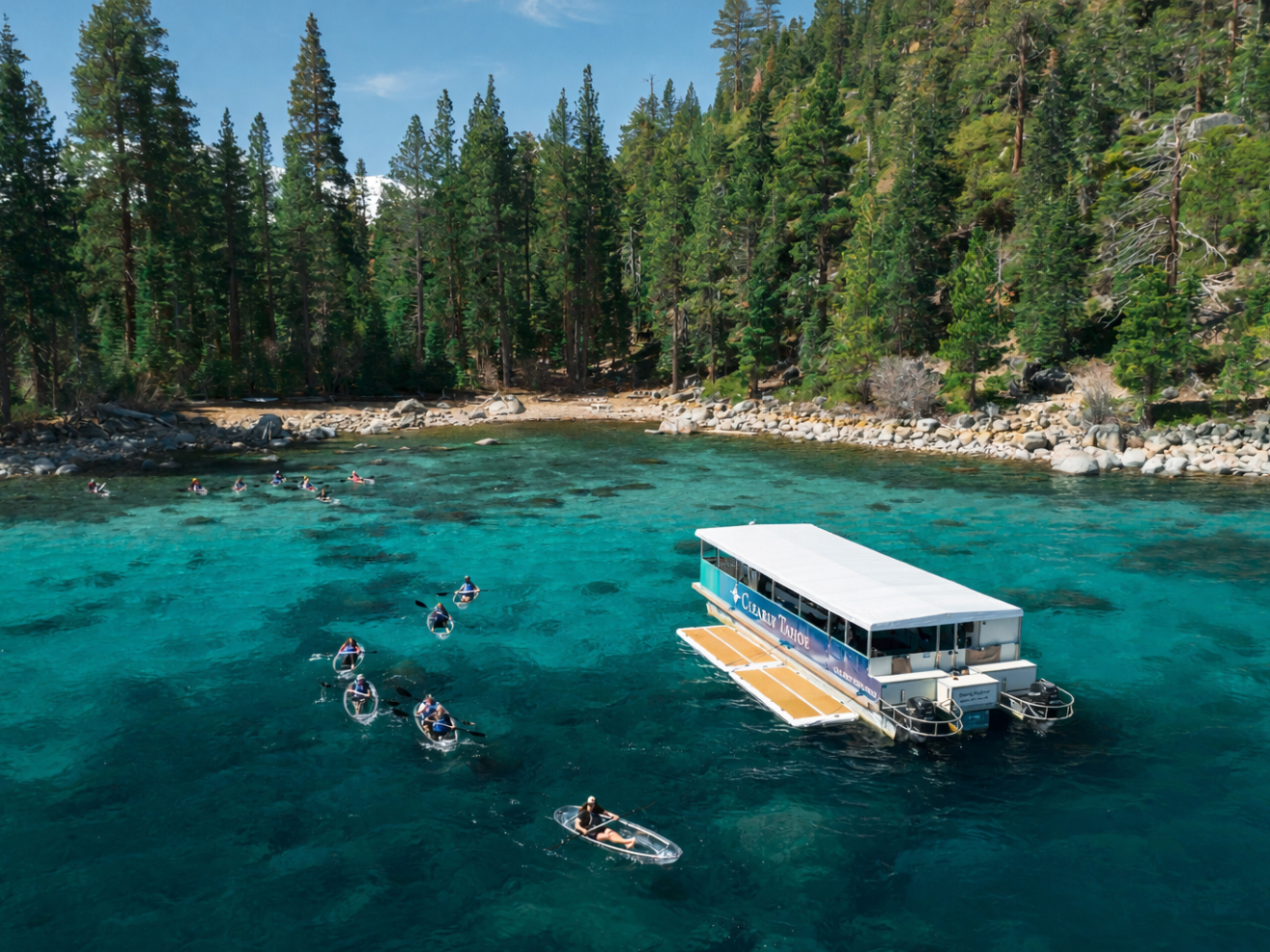 Boat and kayaks on turquoise lake with pine forest shoreline.