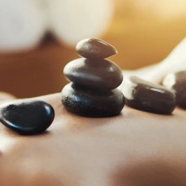 Hot stones on a person's back during a massage therapy session.