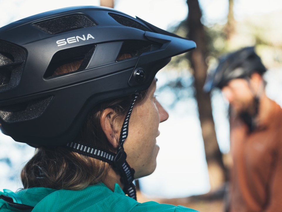 Person wearing a bike helmet, outdoors, with trees in the background.
